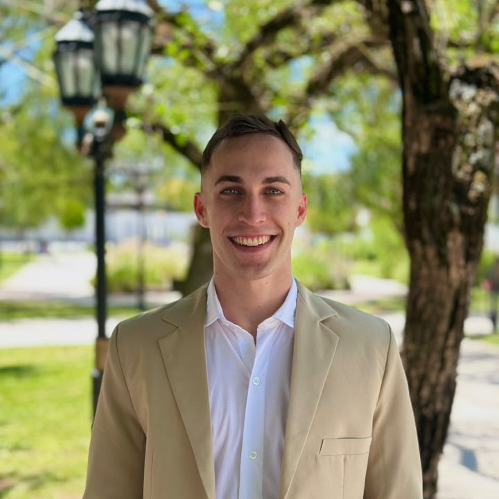 Ezequiel Bobbio sonriendo en un parque de Buenos Aires, con saco beige y camisa blanca
